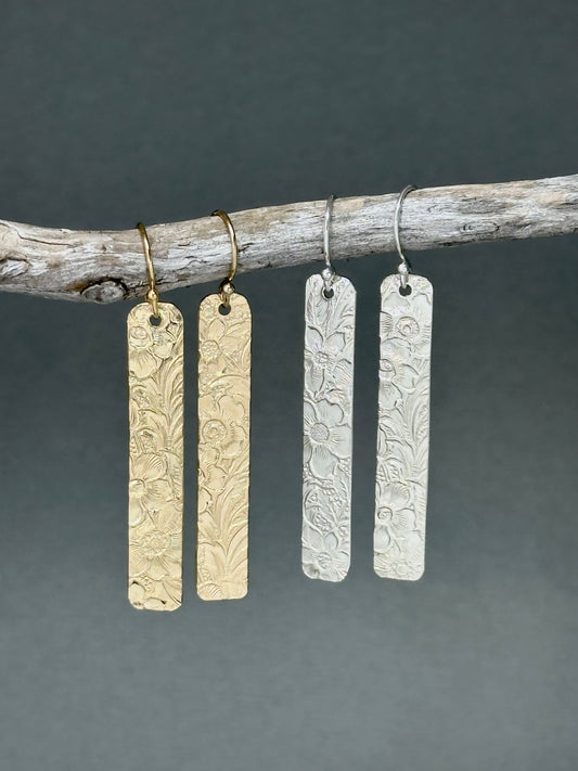 14kt gold filled or sterling bar dangle earrings with a 1/4 inch wide x 1.5 inch long bar with an embossed vintage floral pattern, hangs from standard ear wires or lever back hooks. hand crafted artisan jewelry by hanni jewelry, harbor springs, michigan.