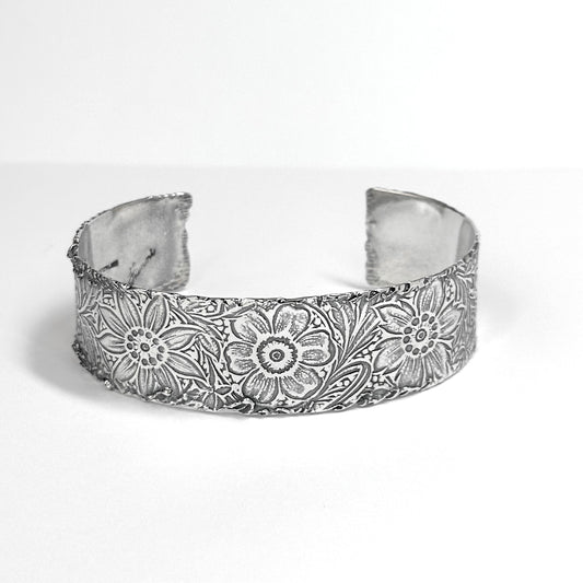 sterling silver 3/4 inch cuff bracelet with vintage flower engraved pattern all around, melted edges for a rustic edgy look made with argentium tarnish resistant silver. artisan silver jewelry handmade by Hanni, harbor springs, Michigan