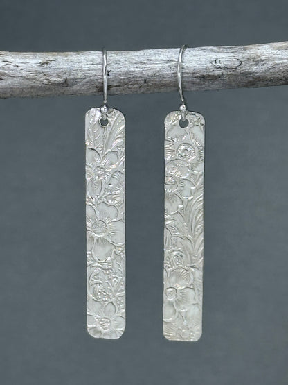 14kt gold filled or sterling bar dangle earrings with a 1/4 inch wide x 1.5 inch long bar with an embossed vintage floral pattern, hangs from standard ear wires or lever back hooks. hand crafted artisan jewelry by hanni jewelry, harbor springs, michigan.